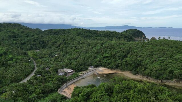 Overhead drone shot of Mountainous Island with Lush Greenery and idyllic Sea cove in Virac, Catanduanes.