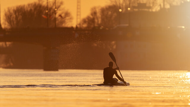 Canoeist paddling the river with a beautiful sunset. Canoeing or kayaker at sunset
