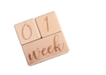 A wooden block showing the date of birth of a newborn child on a white background.