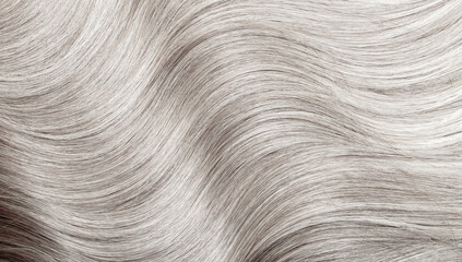 Blond hair close-up as a background. Women's long blonde hair. Beautifully styled wavy shiny curls....