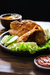 crispy fried fish and salad in plate with sambel paste and sour vegetables soup. Indonesian traditional food
