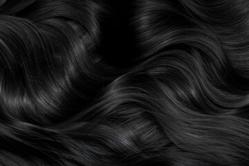 Brunette or black hair. Female long dark hair in black. Beautifully laid curls. Closeup texture in a dark key. Hairdressing, hair care and coloring. Shading gray hair. Background with copy space.