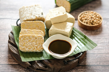 raw tempeh and tofu on a cutting board.  tempeh and tofu made from soybeans seed.