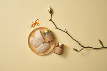 Glass transparent jars with empty label and some edible bird’s nest, cordyceps (Ophiocordyceps sinensis) on pastel background. Bird’s nest and cordyceps is a collaboration of luxury food
