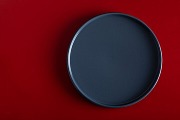Blue plate on a red background. View from above.