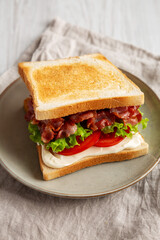 Homemade BLT Sandwich (Bacon, Lettuce and Tomato) on a Plate, side view.