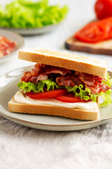 Homemade BLT Sandwich (Bacon, Lettuce and Tomato) on a Plate, side view.