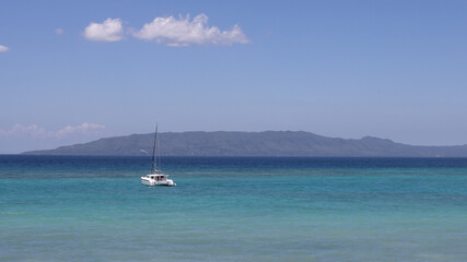 beautiful sea view, with turquoise water and clear, blue sky, a lonely yacht in the sea