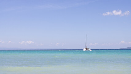 Fototapeta premium beautiful sea view, with turquoise water and clear, blue sky, a lonely yacht in the sea