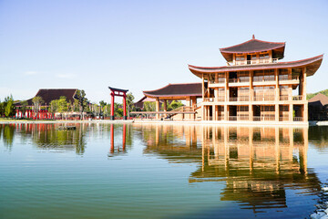 Obraz premium Hinoki Land building (Bann Mai Hom Hinoki) with red torii gate in Chiang Mai Thailand. Japanses building style beside the lake. New tourist attraction in Chiang Mai, Thailand.