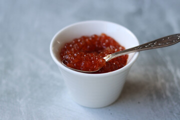 Salmon caviar in a small white bowl. Simple composition still life with seafood.