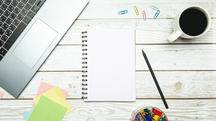 Wooden office desk with laptop, notebook and pen on white background. Top view. Flat lay. Business concept.