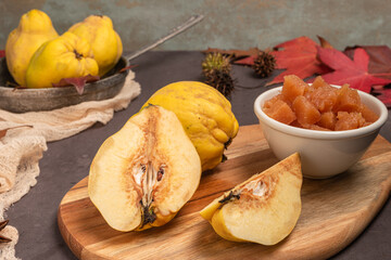 Quince fruit and bowl with quince cheese or marmelada is a sweet, thick jelly made of the pulp of the quince fruit. Dulce de membrillo in Spain