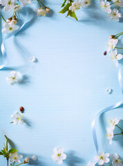 Art Spring flower border on blue background; white spring blossom border