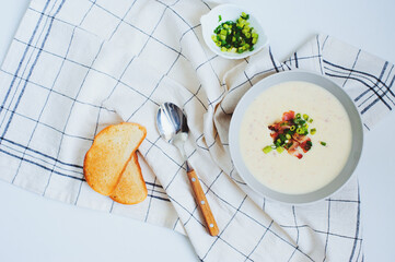potato cream soup with bacon and green onion served in bowl on white background. Delicious food for...