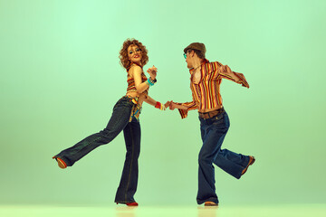 Incendiary dance. Emotional man and woman in retro style clothes dancing disco dance over green...