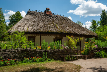 Plakat Old ancient ukrainian village house with flowers, nature at summer time, Ukraine traditions and history