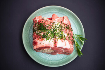 raw pork meat stuffed with sauce for cooking in the oven on a dark background