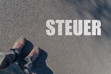 Steuer als Schlagwort auf Asphalt 