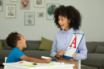 A little boy learns the letter A with a private English tutor during a lesson at home