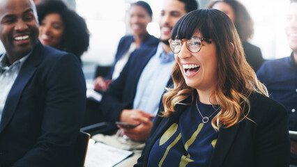 Laughter is a great tool for encouraging learning. Shot of a happy young businesswoman sitting in...