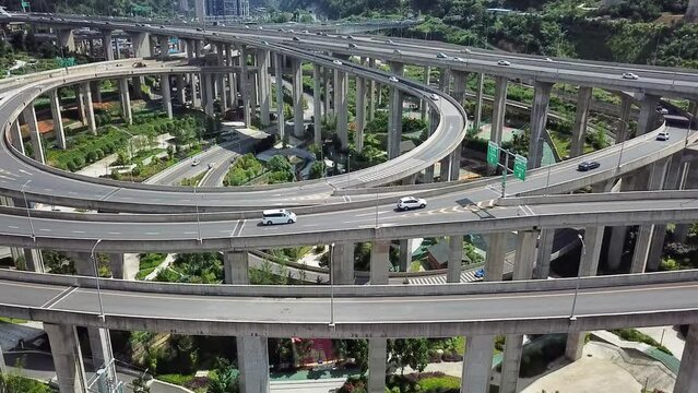 Aerial shot of circular roads and highways floating on bridges and cars driving on them, Huangjuewan interchange. 