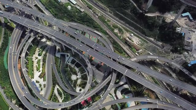 Aerial shot of circular roads and highways floating five levels exchange in Chongqing and cars driving on them, Huangjuewan exchange. Long shot. 