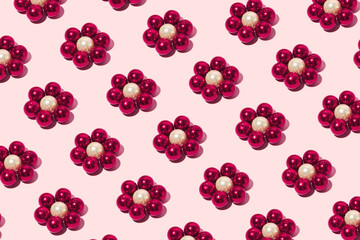Flowers made of pearl beads, creative floral pattern, pastel pink background. 