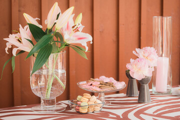 Candy bar with various sweets and pastries on the table. Still life floral arrangement