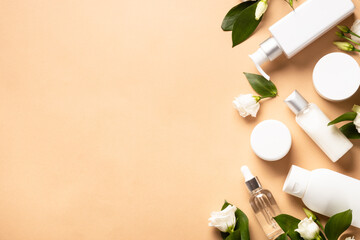Fototapeta na wymiar Natural cosmetic products. Cream, serum, tonic with green leaves and flowers. Flat lay image with copy space.