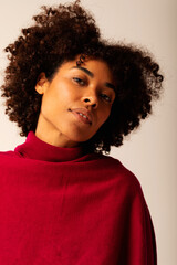 afro haircut Brazilian woman portrait. She is wearing a red sweater 