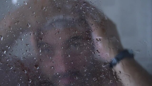 Man shampooing his hair to keep his hair clean and good looking. The man is on a health routine by taking a cold shower.