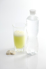 Glass with soluble vitamin C on a white background.