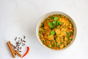 Indian Chicken Curry in a Bowl with Spices Top Down Photo