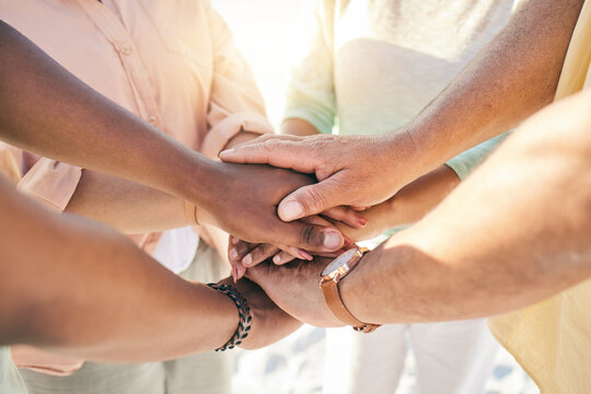 Group of people hands stacked outdoor for teamwork, community support and collaboration in prayer or faith. Circle of friends closeup with hand together sign for solidarity, praying and team building