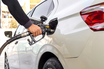 Man hand refuelling the car, Pumping gasoline fuel in car at petrol station. higher oil prices