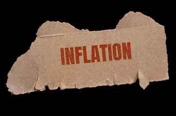 Inflation word written on torn paper. Economy and finance concept.