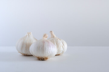 Obraz premium Three garlic and garlic cloves isolated on a white background