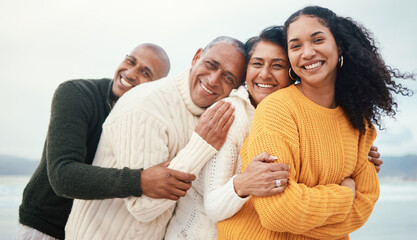 Portrait, happy family and hug at the beach by siblings with mature parents on holiday, happy and bonding. Face, love and senior couple happy on retirement vacation while embracing adult children