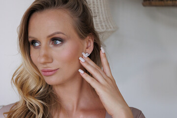 Fototapeta premium Portrait of beautiful blond woman. Young blond lady in spacious room. 