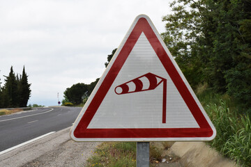 Panneau routier : danger aux vents violents.