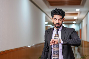Indian businessman or employee looking time in watch