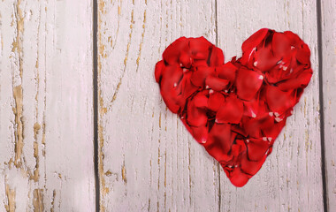 The heart of the most delicate rose petals on wooden background. copy space