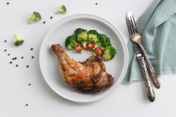 Healthy food grilled chicken has broccoli vegetable in plate on white wood table.