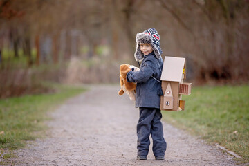 Little child, blond boy with pet dog, carying home on his back, kid, having paper house