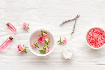 Pink roses cosmetic products set with flowers essential oil. Beauty care concept.