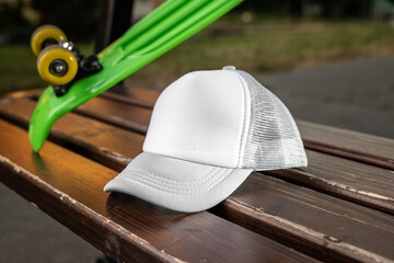 Trucker cap, snapback, grey with white front, grey mesh. In location on playground. Mock-up for branding