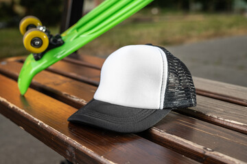 Trucker cap, snapback, black with white front, black, mesh. In location on playground. Mock-up for branding