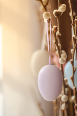 Fresh flowering branches decorated with easter colorful eggs in a vase. Holiday concept, home Decoration, happy childhood and family traditions. Close up view. Vertical photo.