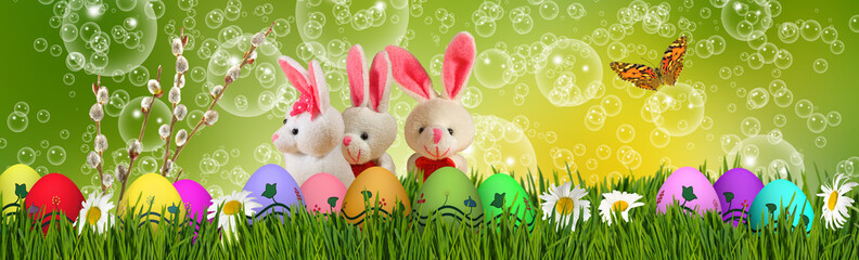 Easter greeting card on which Easter eggs, a rabbits  with beautiful flowers in the background
